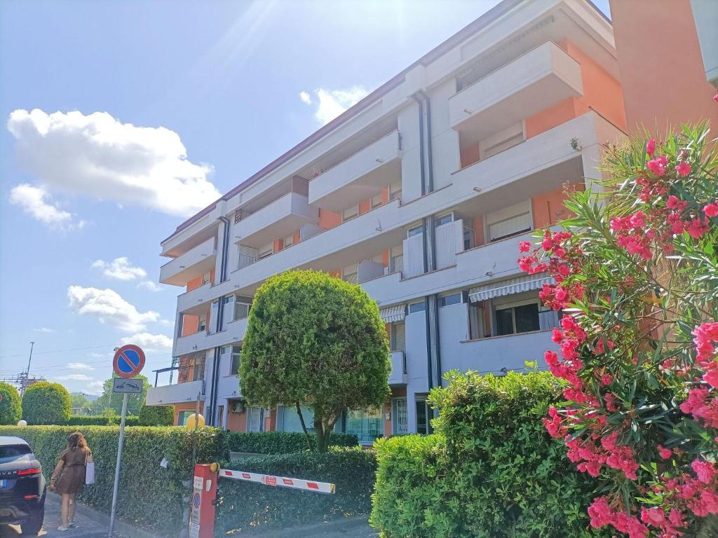 un edificio con flores rosas delante de él en Large Panoramic Terrace 2-bedroom in Viareggio sleeps 4, en Viareggio