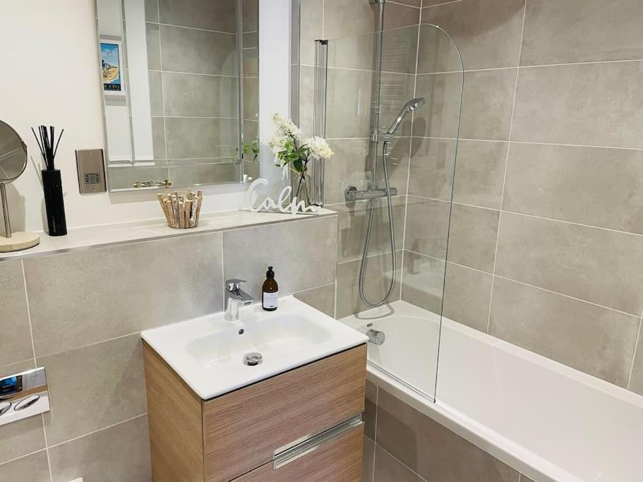 a bathroom with a sink and a shower and a tub at Salt Yard Apartment, Parking and Terrace, Whitstable in Whitstable