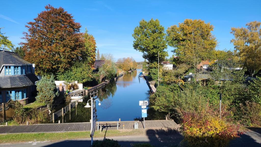 Blick auf einen Fluss mit Bäumen und Häusern in der Unterkunft Landhotel Strandallee in Wunstorf