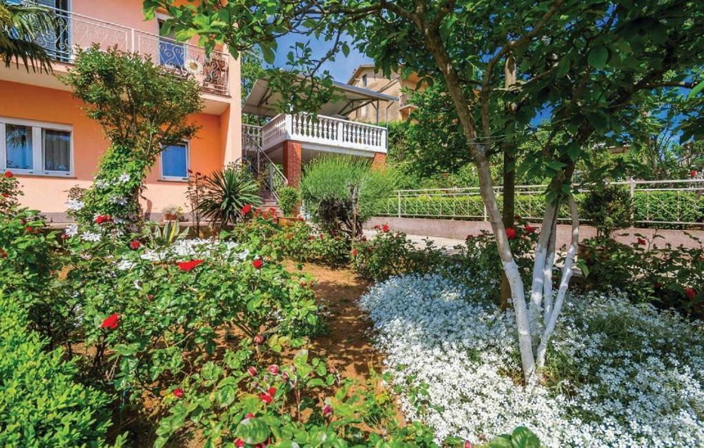un jardin en face d'un bâtiment fleuri dans l'établissement Apartment Ana, à Rijeka