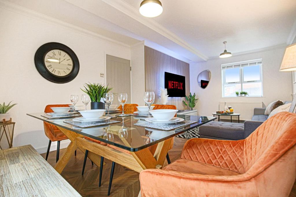 a dining room and living room with a table and chairs at Central MK House - Sleeps Up To 9 Guests - Free Parking, Fast Wifi, Pool Table and Smart TV with Sky TV and Netflix by Yoko Property in Milton Keynes