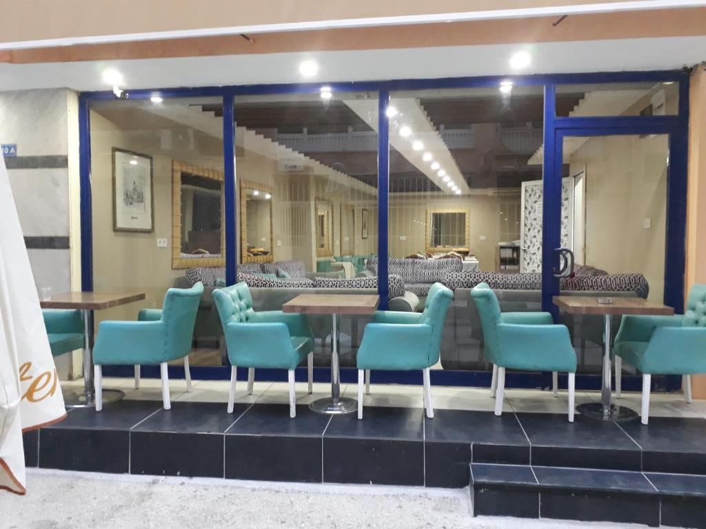 ein Restaurant mit blauen Stühlen und Tischen in einem Zimmer in der Unterkunft Nest Hotel ANTALYA in Antalya