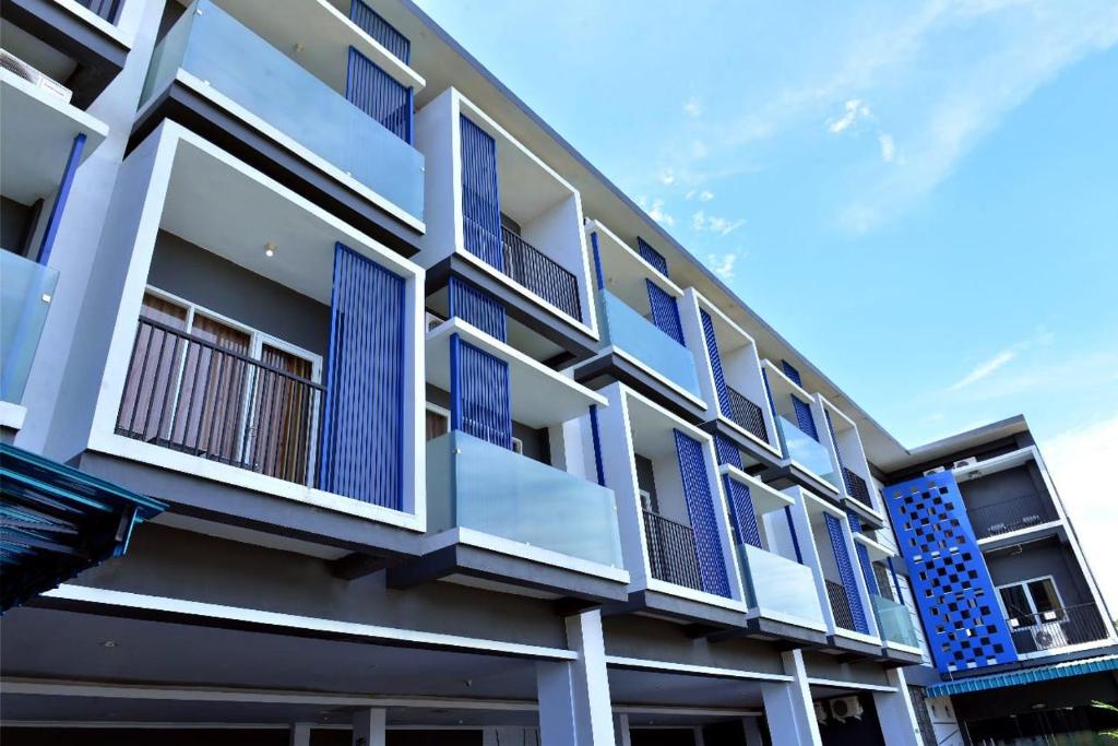 un edificio con ventanas azules y balcones. en Permata Inn Slawi, en Procot