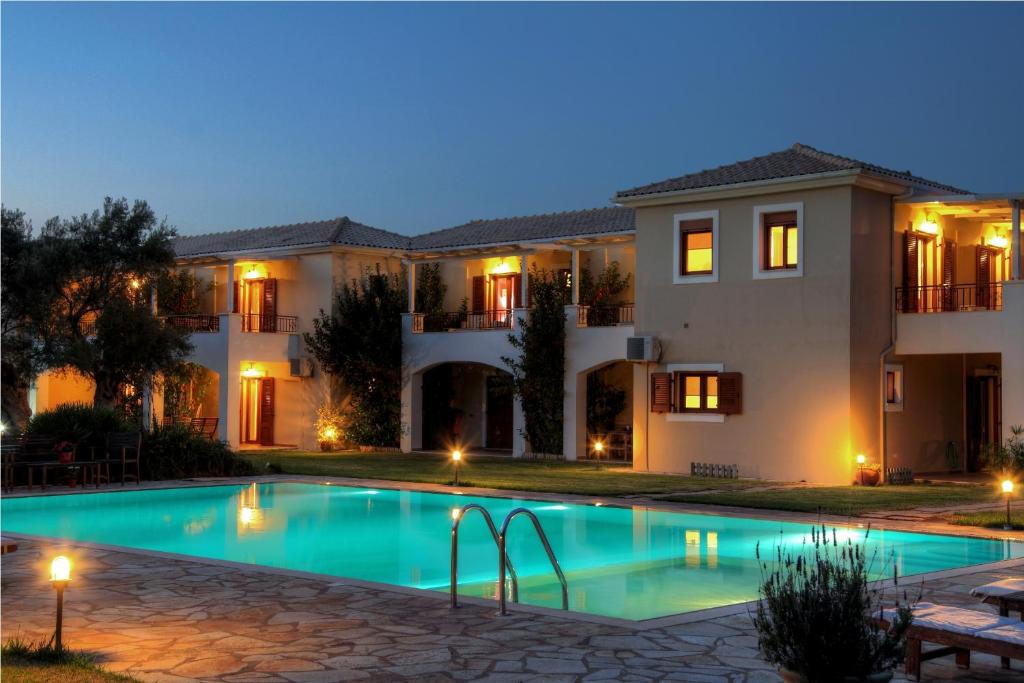 a villa with a swimming pool at night at Olivastro Villa in Lefkada Town