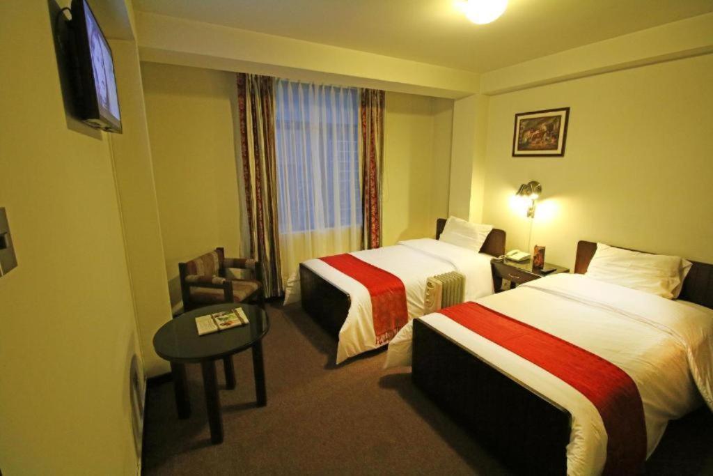 a hotel room with two beds and a television at Camino Real Puno in Puno