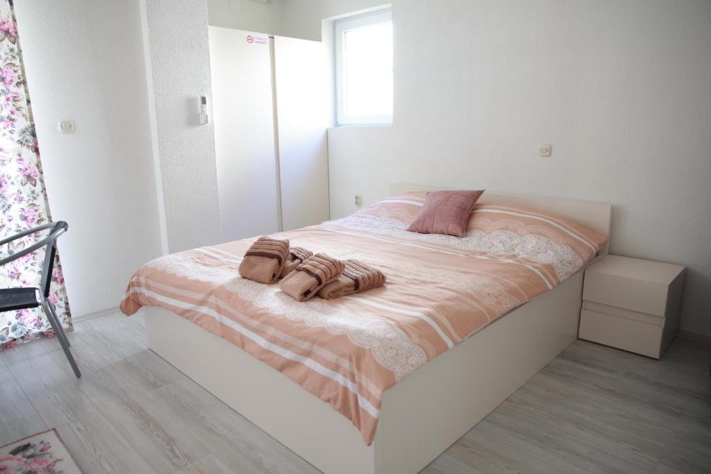 una camera da letto bianca con un letto con scarpe marroni di Cavleski rooms a Prilep