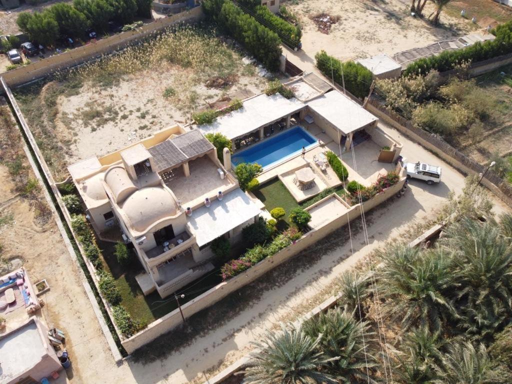 una vista aérea de una casa con piscina en Bequest, en Qaryat at Ta‘mīr as Siyāḩīyah
