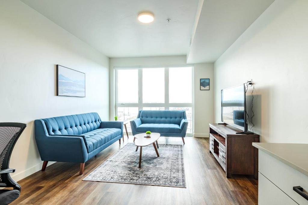 a living room with two blue couches and a tv at Luxe Downtown Condo with Amenities 78 in Salt Lake City