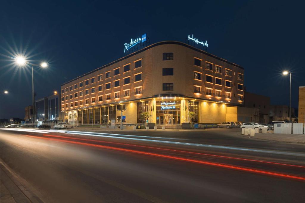 a building at night with cars speeding past it at Radisson Blu Hotel, Buraidah in Buraydah