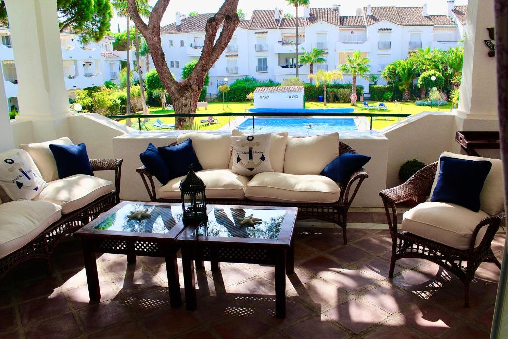 a living room with a couch and chairs and a pool at Apartment in El Presidente Beach Side New Golden Mile in Estepona