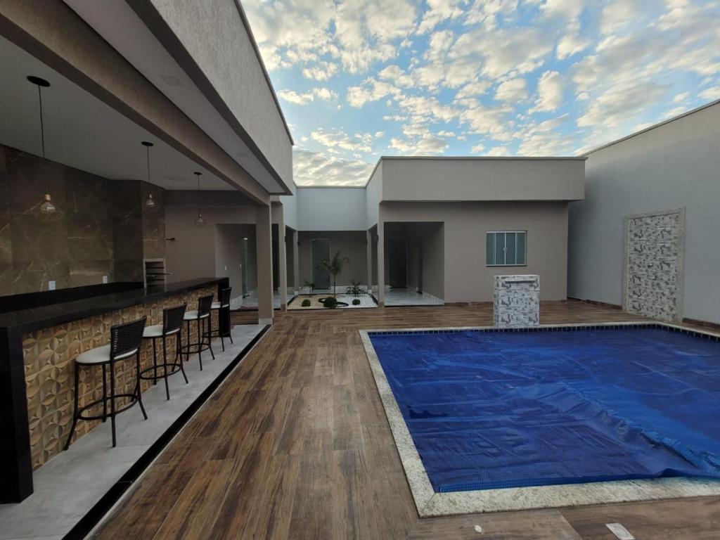 una piscina en una habitación con mesa y sillas en CASA ARUANÃ 5 SUITES, en Aruanã