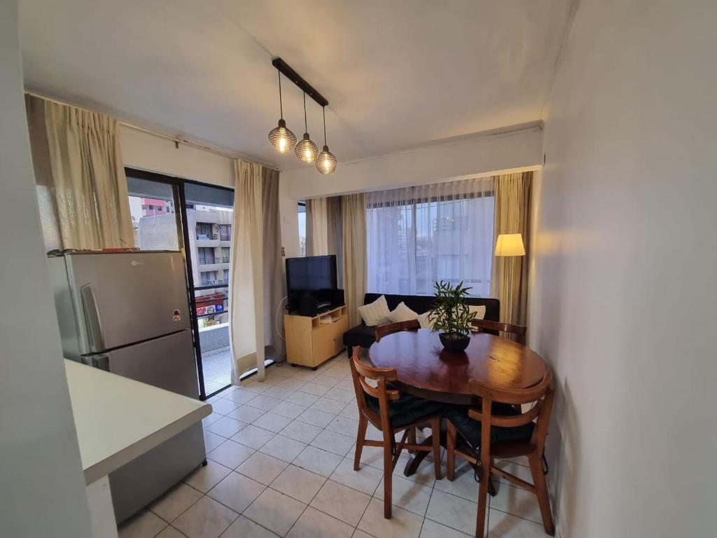 ein Wohnzimmer mit einem Esstisch und einer Küche in der Unterkunft Departamento juan martines in Iquique