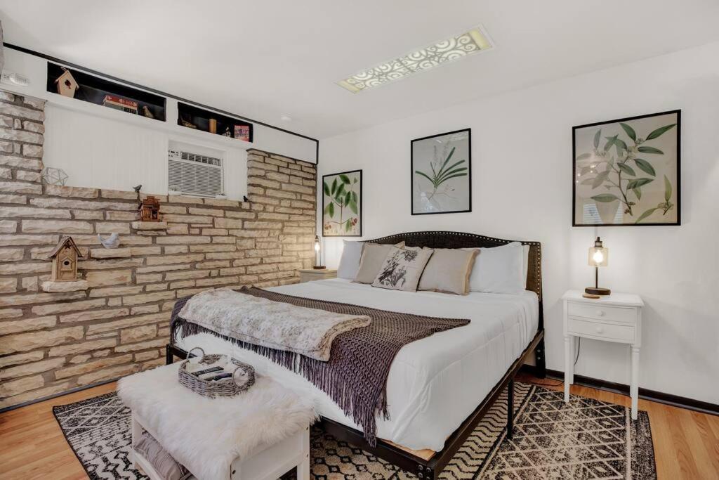 a bedroom with a large bed and a brick wall at The Bird Haus in Fredericksburg