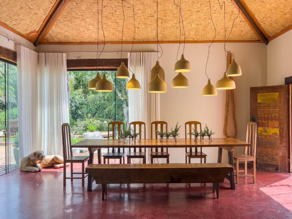 a dining room with a table and chairs and pendant lights at Pousada Vagalume in Tiradentes