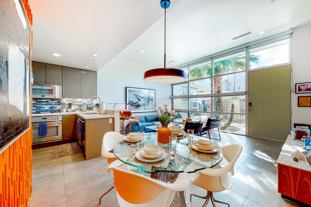 a kitchen and dining room with a glass table and chairs at Cerritos Style Permit #48864 in Palm Springs