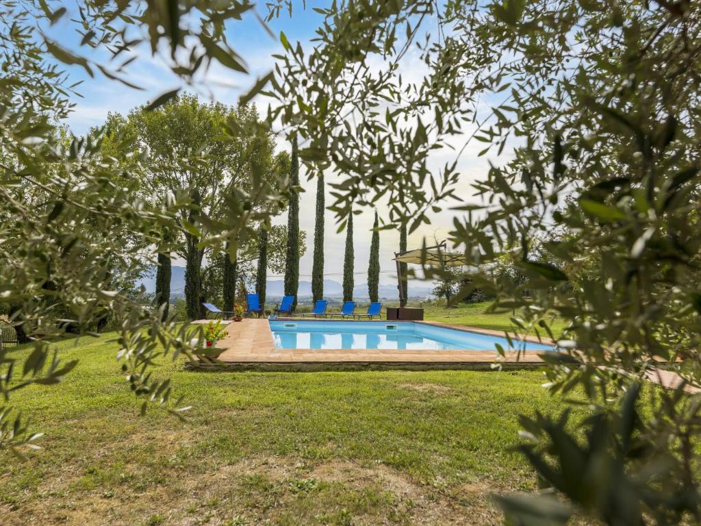 a swimming pool in a park with trees at Private villa with swimming pool in the heart of Umbria in Bevagna