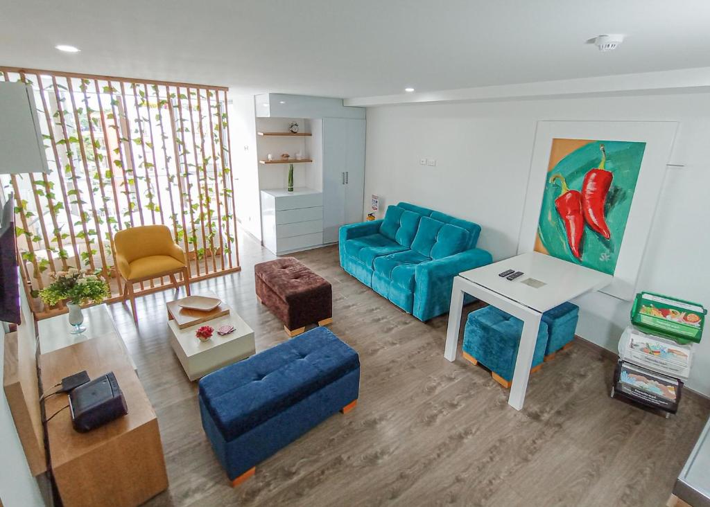 ein Wohnzimmer mit einem blauen Sofa und einem Tisch in der Unterkunft Apartamento Loft Edificio Soho 905 in Armenia