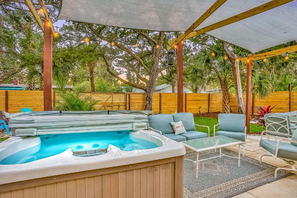 a hot tub in a yard with chairs and a table at Salt & Light in St. Augustine