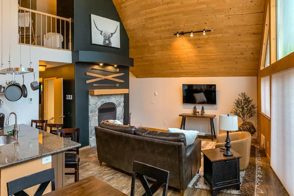 een woonkamer met een bank en een open haard bij Snoqualmie Summit Chalet in Snoqualmie Pass