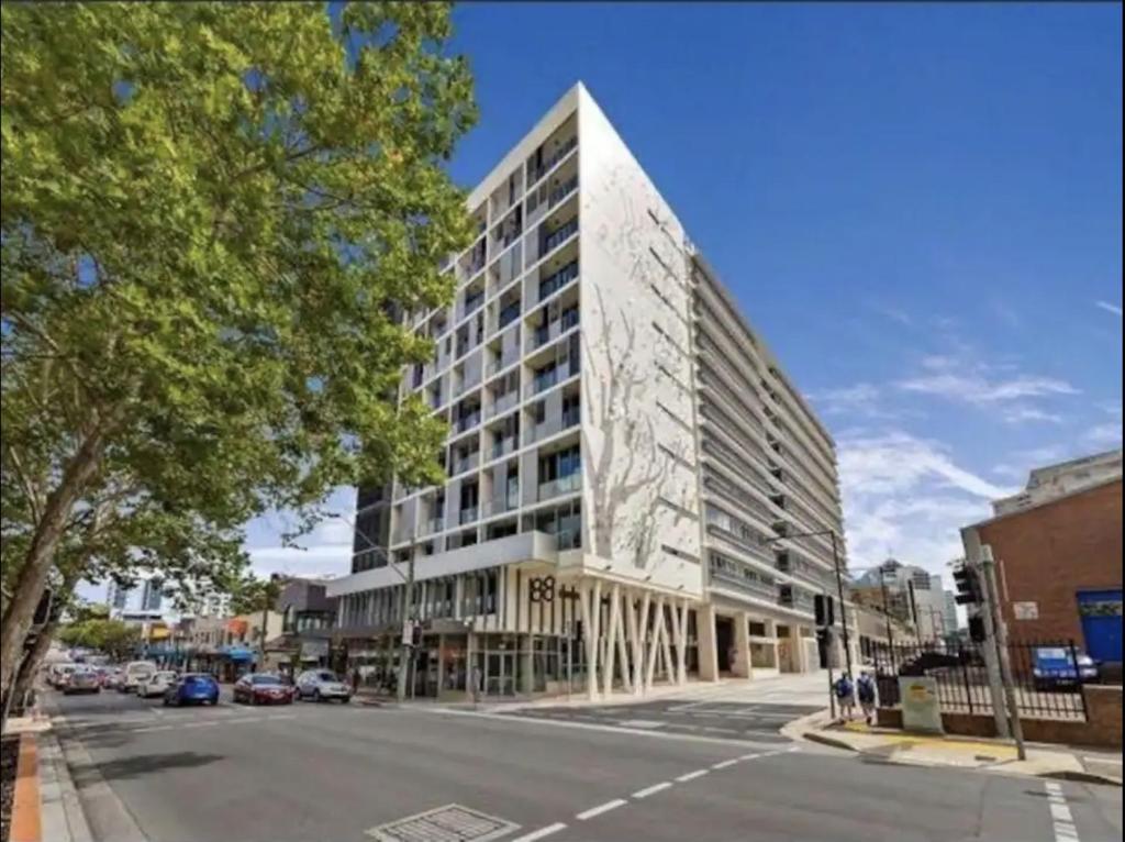 雪梨的住宿－Broad Land Premium Apartments Chatswood Sydney，城市街道上一座高楼 ⁇ 染