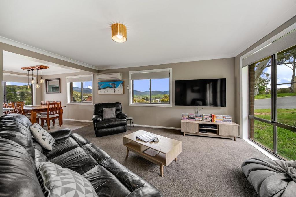 a living room with a couch and a tv at Petersdorf 2 Jindabyne Townhouse in Jindabyne