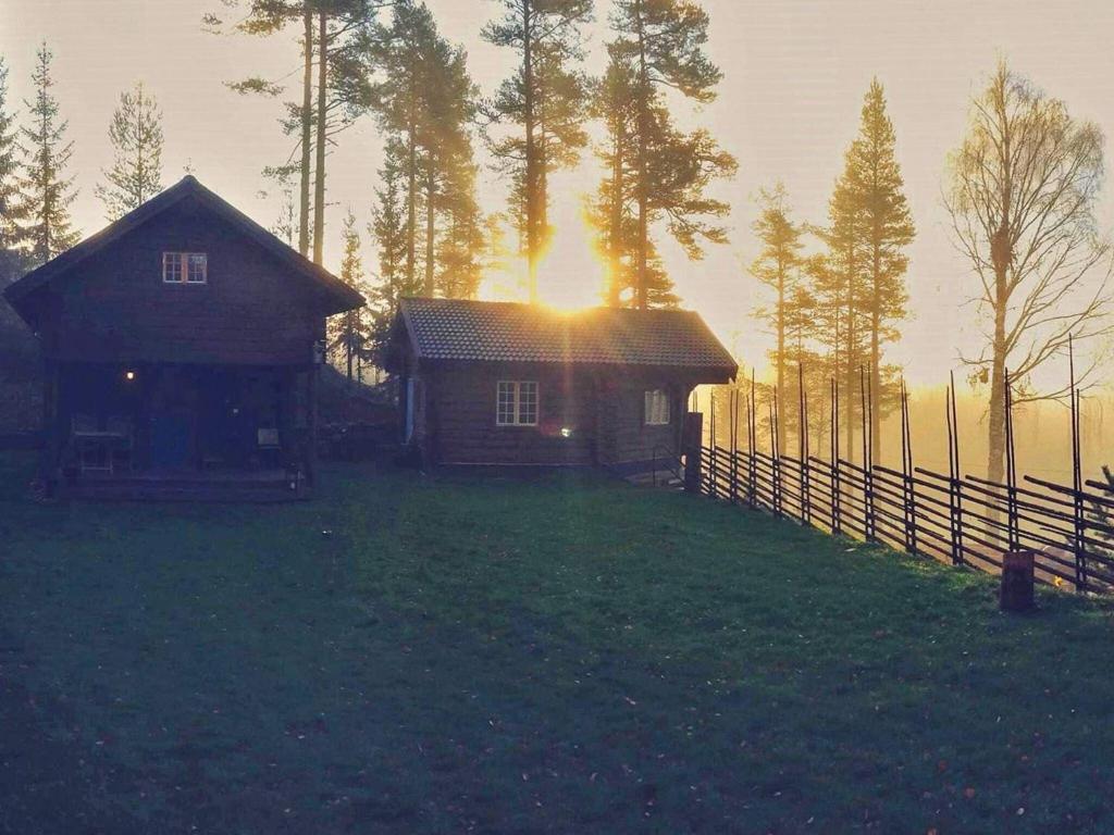 a house on a hill with the sun setting behind it at Holiday home MORA III in Börka