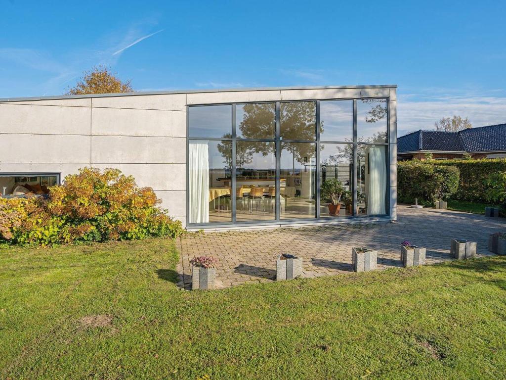 a house with large glass windows and a yard at 6 person holiday home in Væggerløse-By Traum in Væggerløse