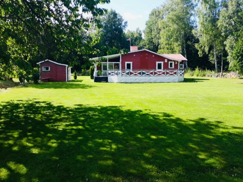 Holiday home MÖLLTORP في Mölltorp: حظيرة حمراء وبيت احمر في ميدان