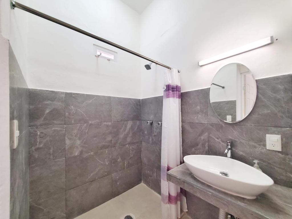 een badkamer met een wastafel en een spiegel bij Quinta Suites in Cozumel