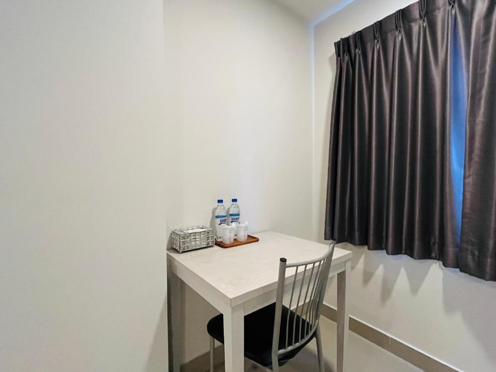 A compact desk and chair beside a curtained window.