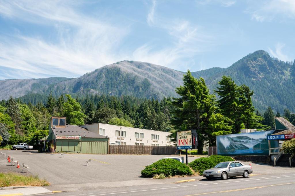 a car parked in a parking lot with mountains in the background at Columbia Gorge Inn in Cascade Locks