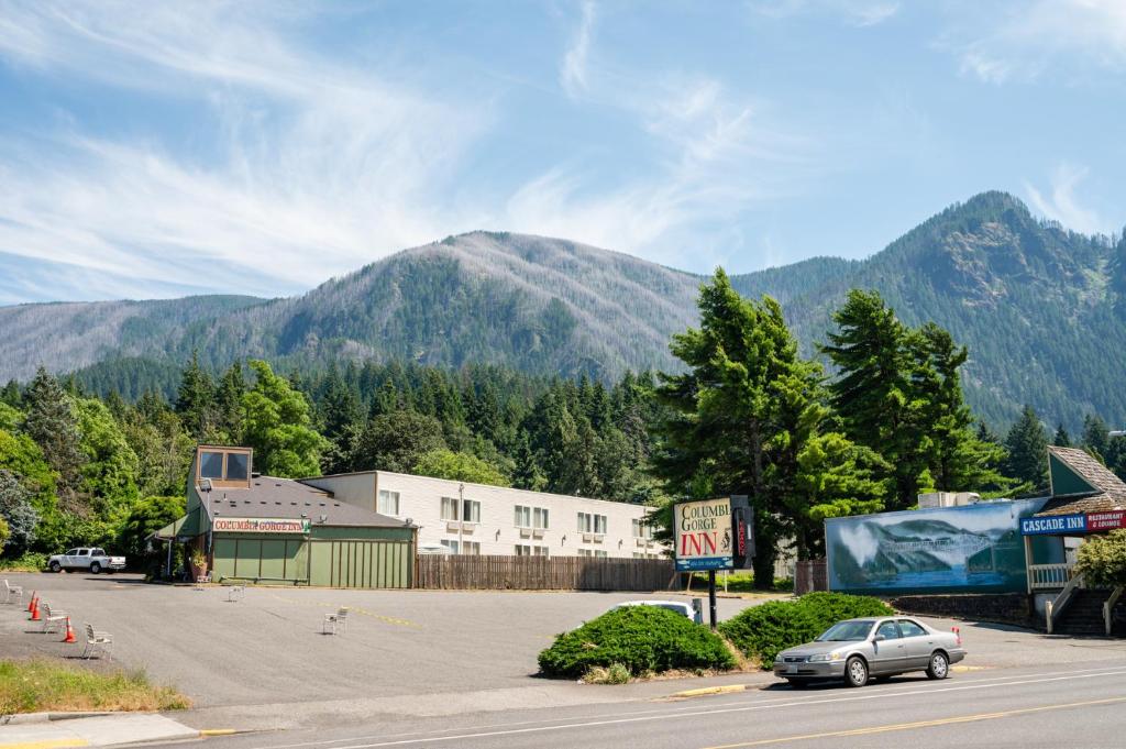 um carro estacionado num parque de estacionamento com montanhas ao fundo em Columbia Gorge Inn em Cascade Locks