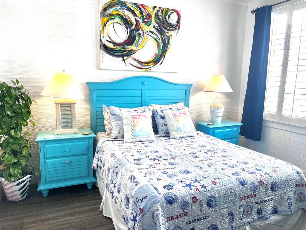 - une chambre avec un lit bleu et 2 tables de chevet dans l'établissement Romantic Studio in the Heart of Palm Beach, à Palm Beach