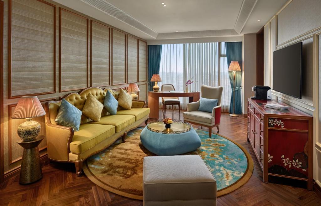ハノイにあるGrand Mercure Hanoiのソファとテーブルのあるリビングルーム
