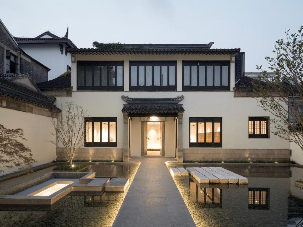 a house with a pond in front of it at Jiangnan House Jingwenli in Suzhou