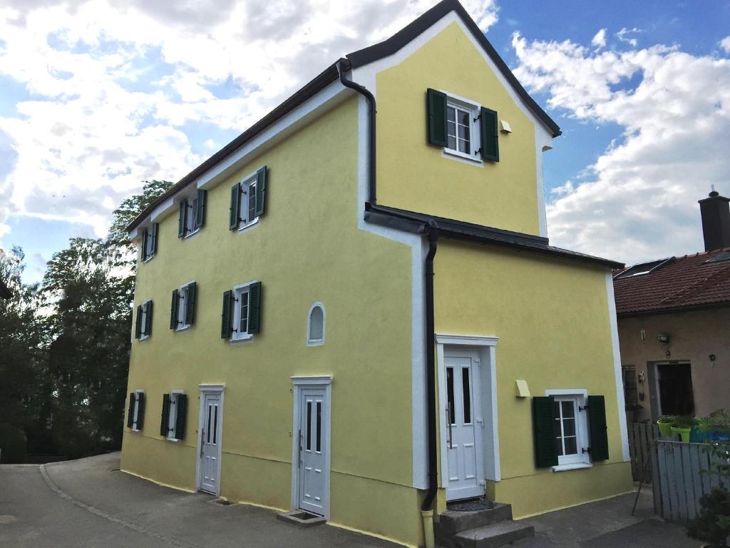 ein gelbes Gebäude mit weißen Türen und Fenstern in der Unterkunft Haus am Eck - Gästehaus und Appartements in Altötting