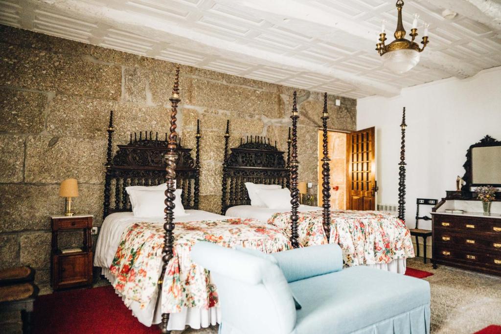 una camera con un grande letto e una sedia di Quinta De Guimaraes a Miguas