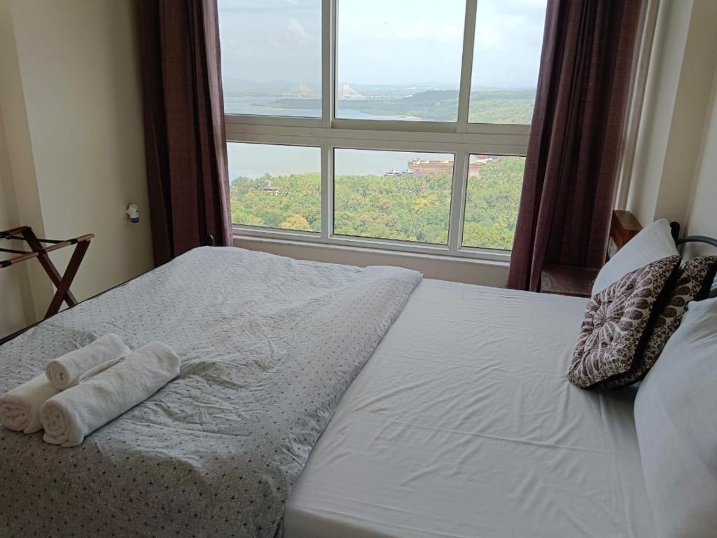 een bed met twee handdoeken voor een raam bij Nirvana Paraiso in Marmagao