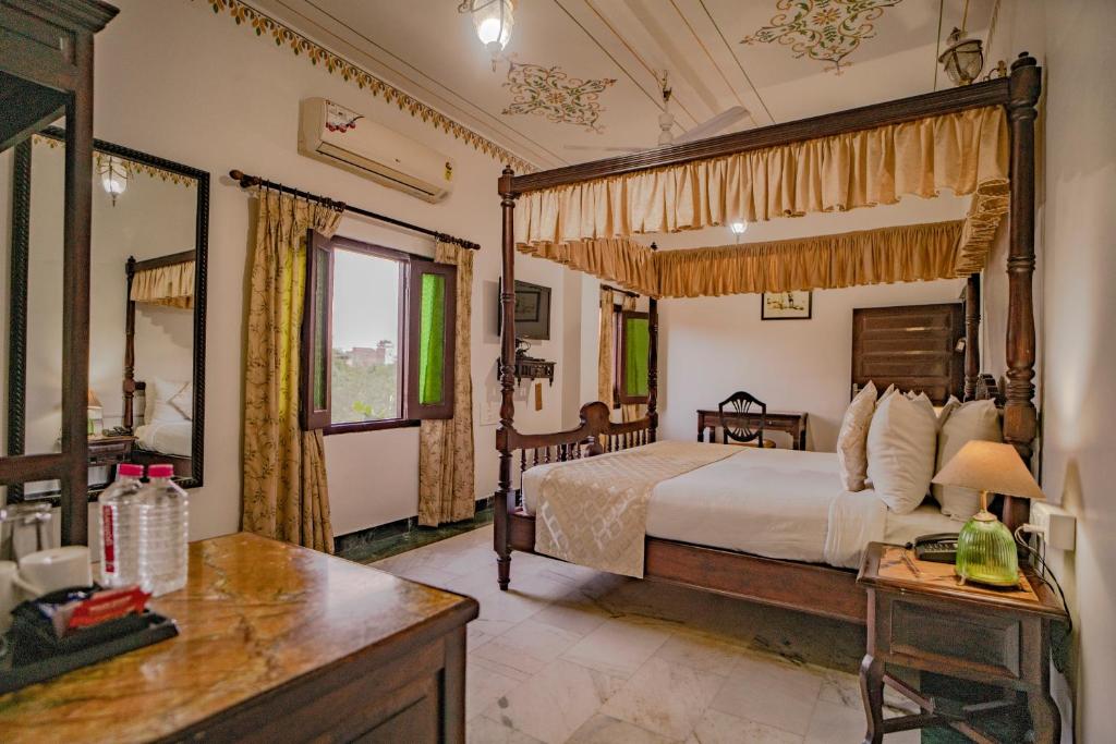 een slaapkamer met een bed en een bureau in een kamer bij The Lavitra Udaipur in Udaipur