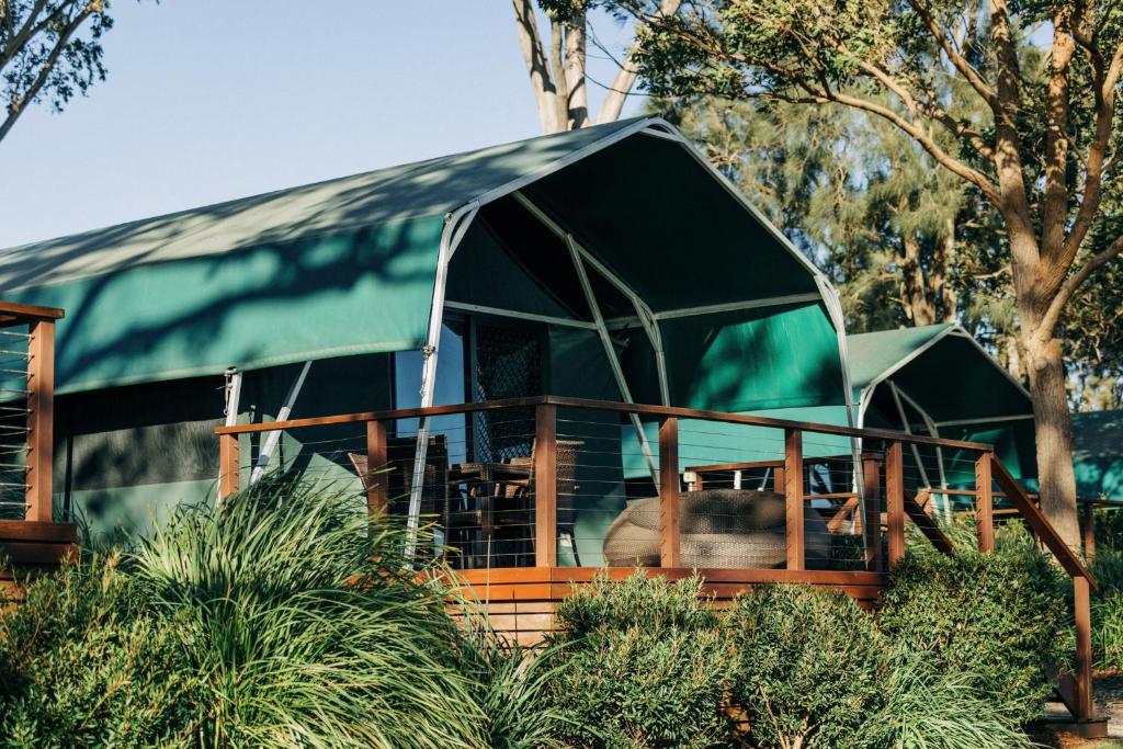 une maison avec une tente verte dans les arbres dans l'établissement Thou Walla Sunset Retreat, à Soldiers Point