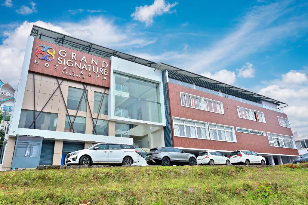 a group of cars parked in front of a building at Grand Signature Hotel & spa in Yercaud