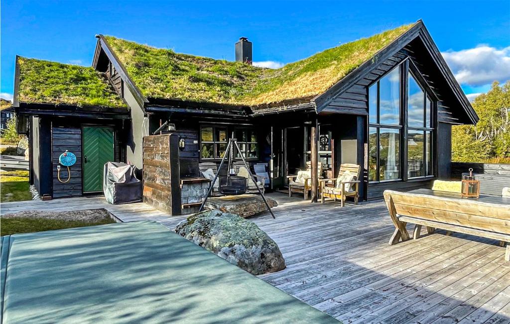 a house with a grass roof with a wooden deck at Amazing Home In seral With Sauna, Wifi And 3 Bedrooms in Åseral