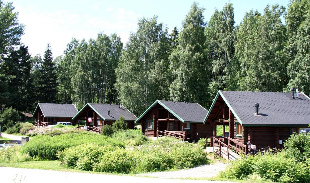 a group of cottages with trees in the background at Rastila Camping Helsinki in Helsinki