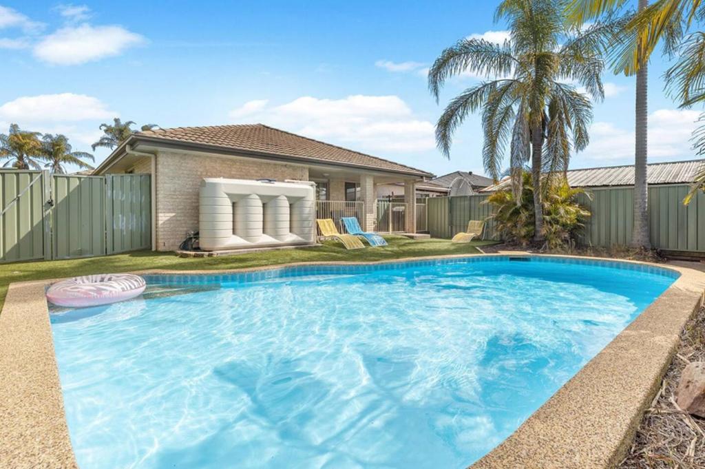 a large blue swimming pool in front of a house at Hunter Home with POOL / CINEMA ROOM / PING PONG in Cessnock