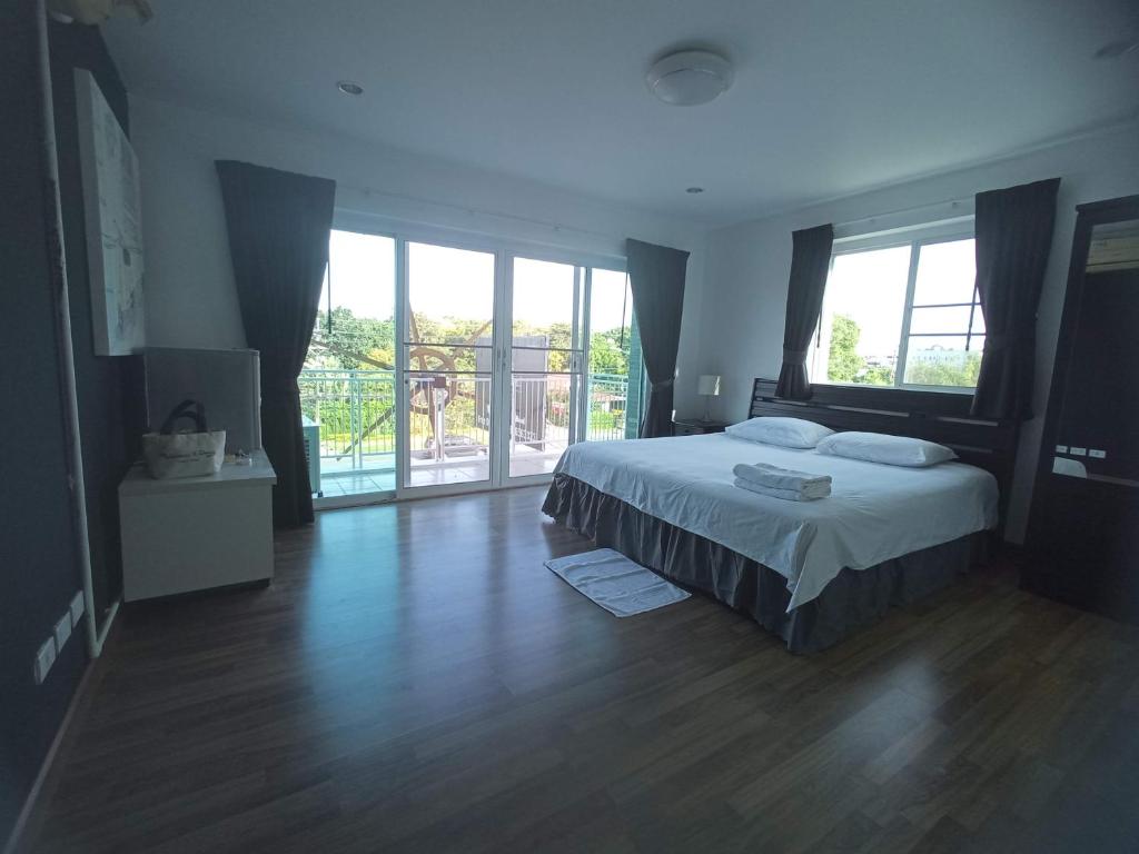 a bedroom with a bed and a large window at Charlie's Angels Hotel Restaurant in Rawai Beach