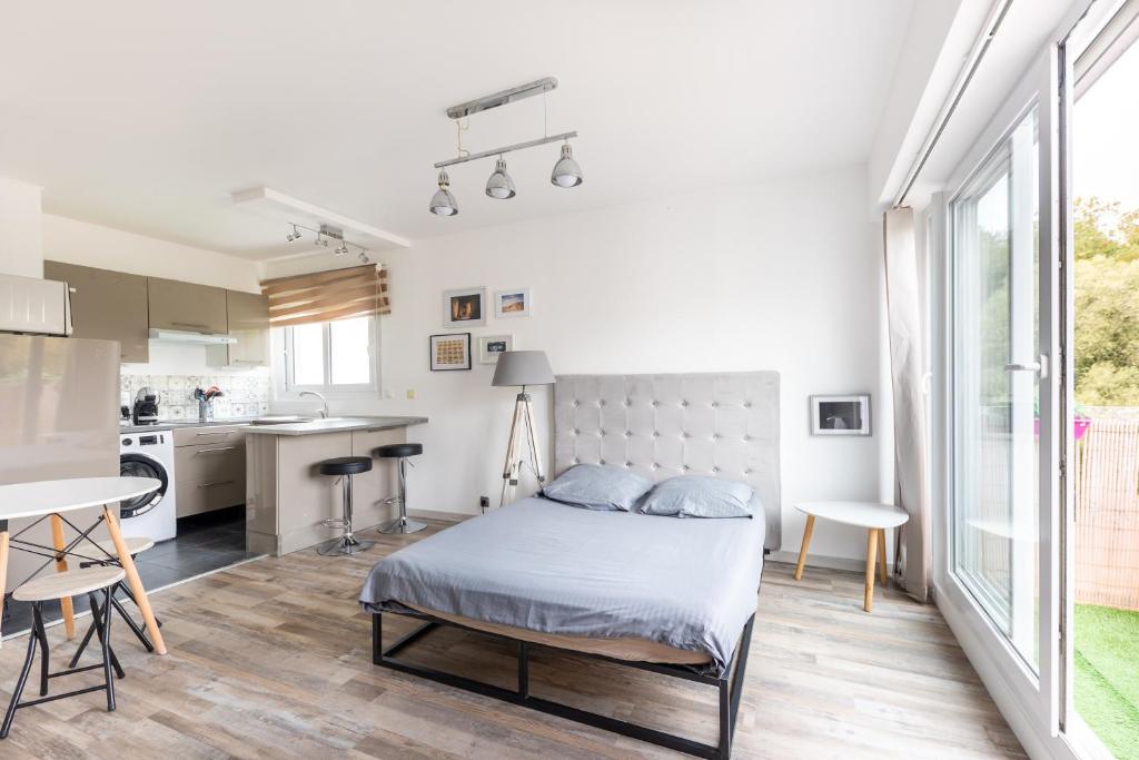 um quarto com uma cama e uma cozinha em Studio neuf proche Disneyland Paris em Meaux
