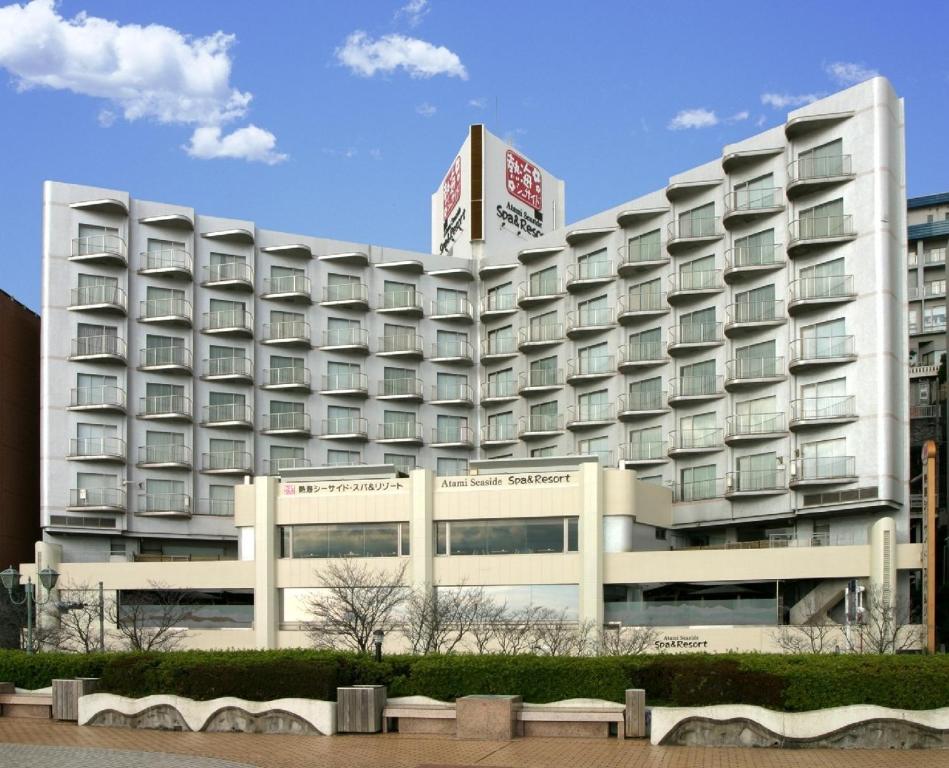 um grande hotel branco com uma placa em cima em Atami Seaside Spa & Resort em Atami