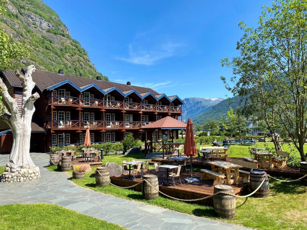 um grande edifício com mesas e cadeiras em frente em Flåmsbrygga Hotel em Flåm