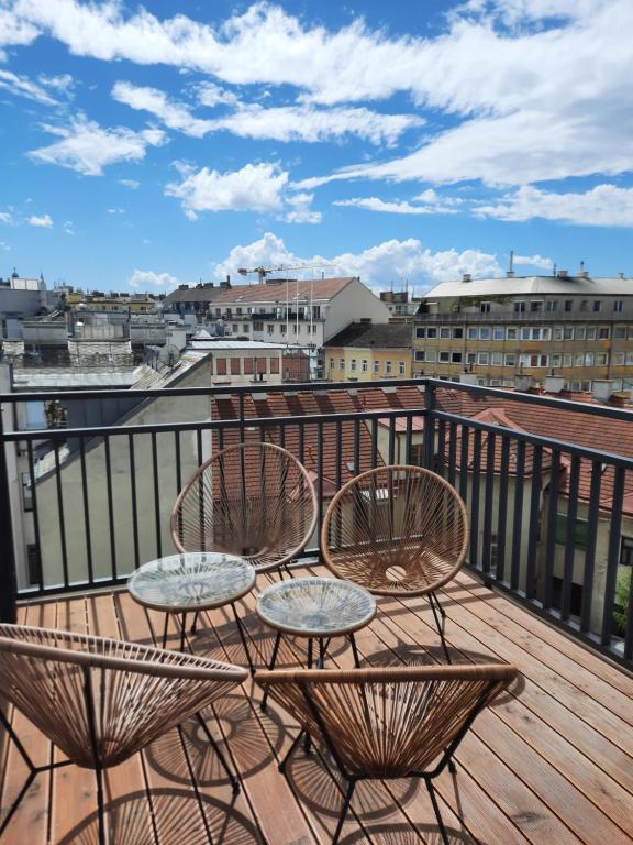 SkySuite Holiday Home في فيينا: فناء مع كراسي وطاولات على شرفة