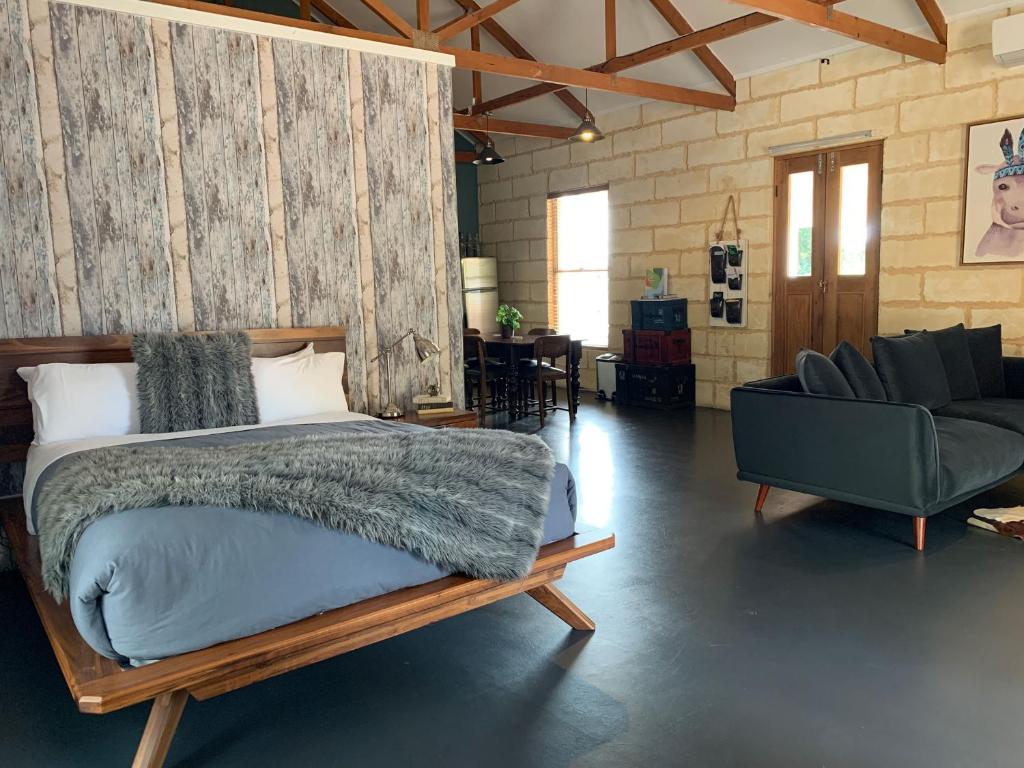 a bedroom with a bed and a couch and a chair at Bella Cosa in McLaren Vale